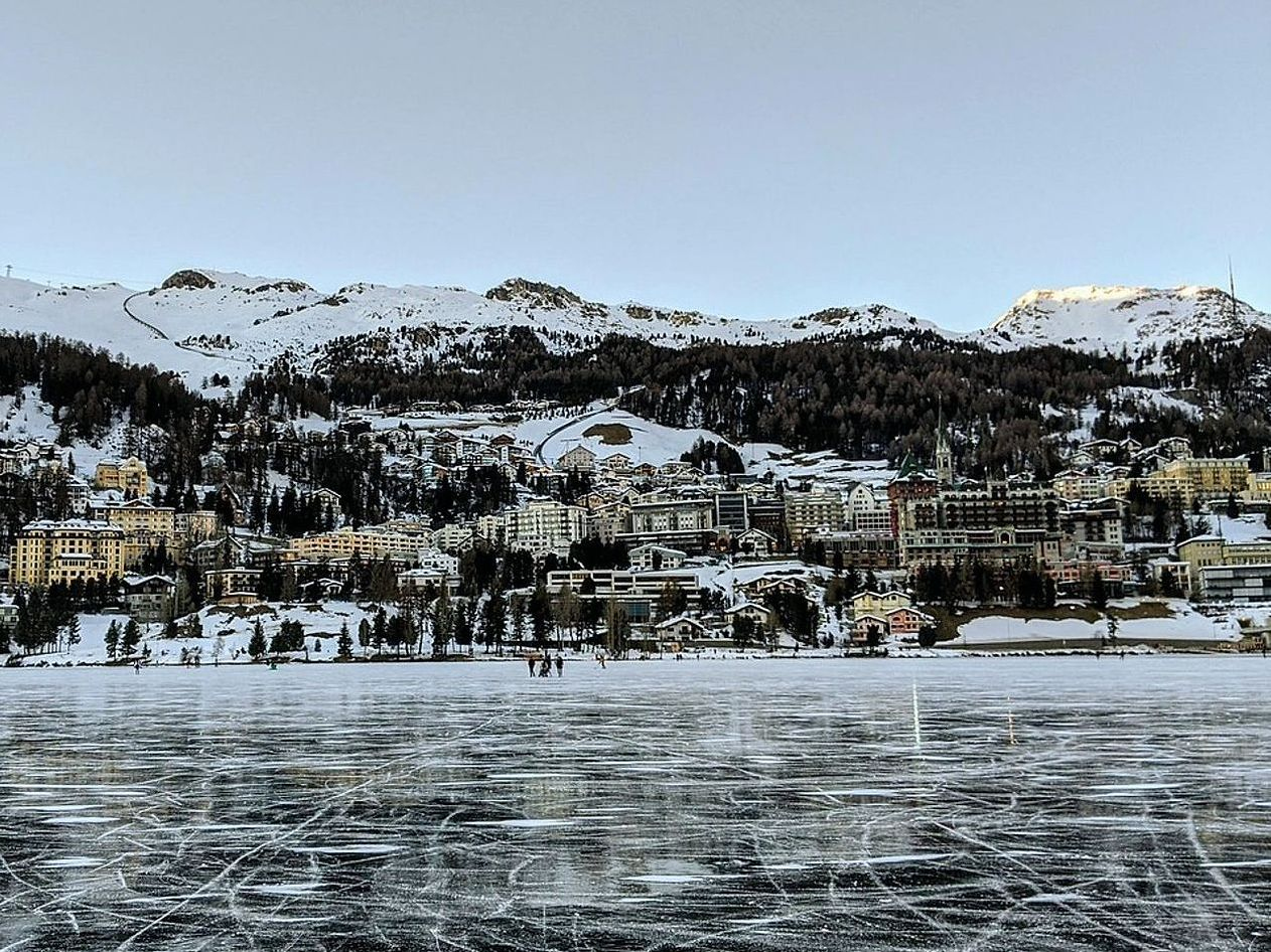 Cabaña en el bosque junto a un lago bajo el hielo en invierno